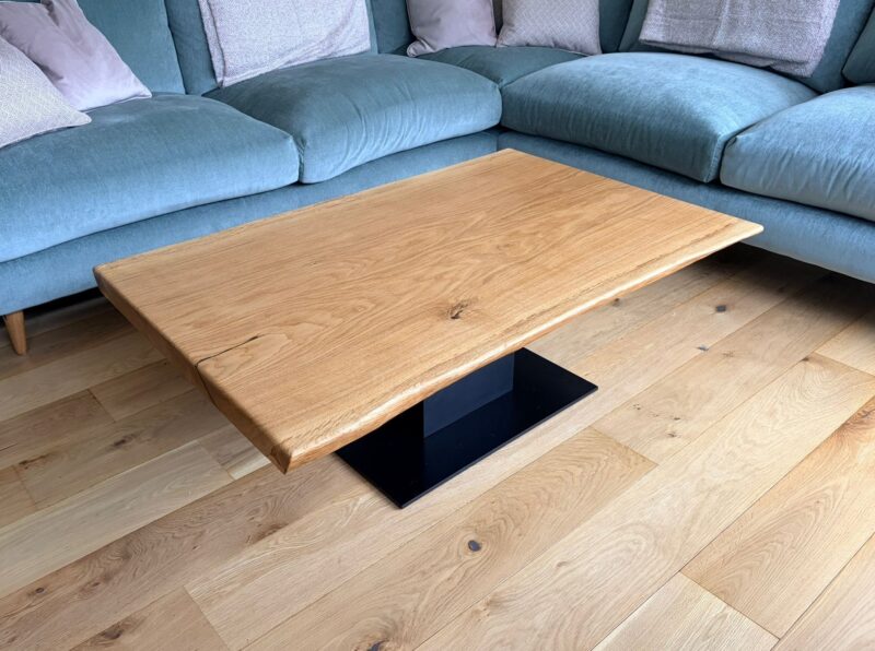 A Timber Row French oak coffee table seen head-on, showing the full black square plinth base