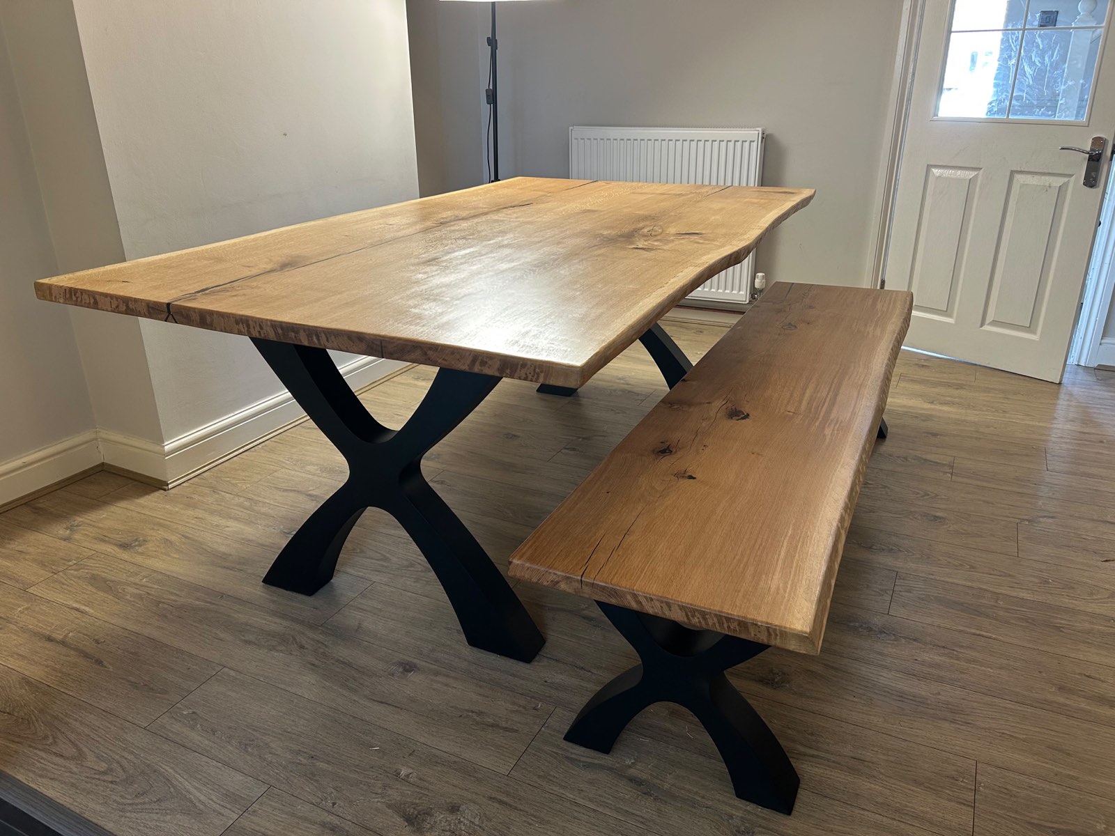 Natural oak dining table with live edge set up in a customer's dining room