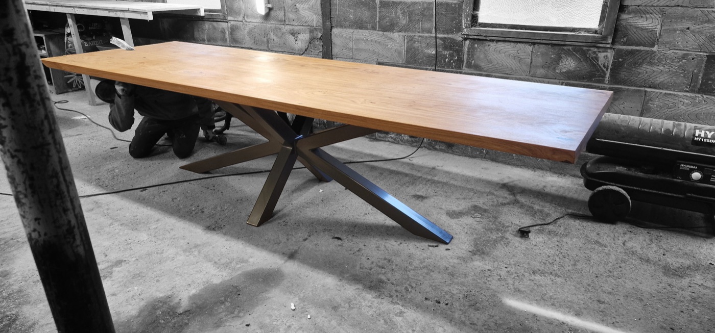 A thick oak top on an X-frame steel base, photographed in the Wickford workshop on the morning of delivery