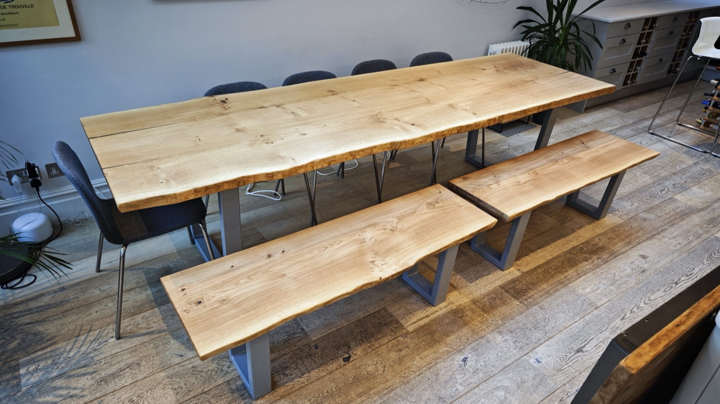 A bespoke live-edge oak dining table with matching benches in an open-plan kitchen-diner