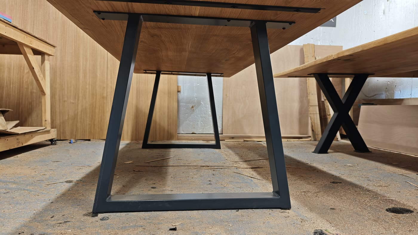 Trapezium steel legs under a French oak table in the workshop