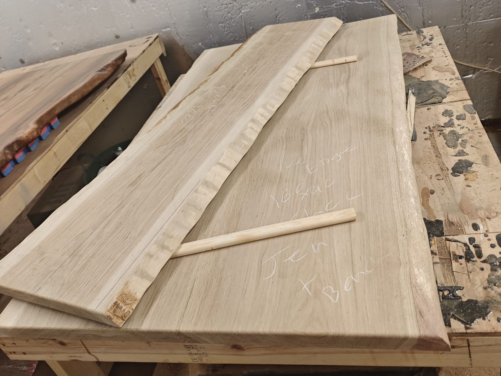 Rough French oak slabs laid out on the bench, bark edges still on, before cutting