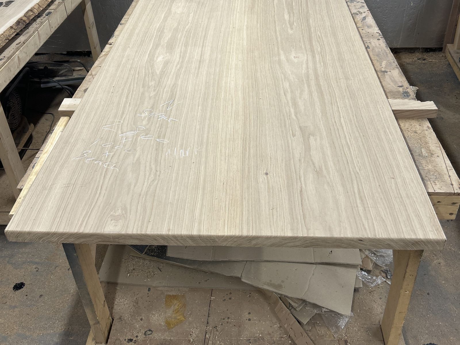 A sanded, unfinished two-slab French oak top on the bench, ready for oil